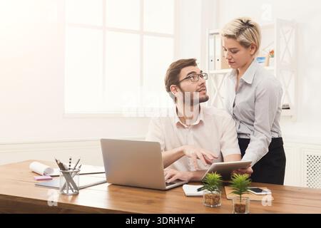 Office Collaboration Between Two Colleagues During a Workday in a Modern Workspace Stock Photo