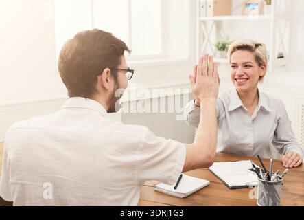 Meeting With Two People Giving a High Five in an Office Setting Stock Photo