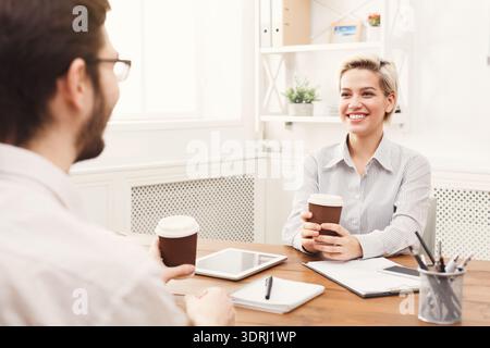 Discussion About Ideas During Coffee Break in Work Setting With Two Coworkers Stock Photo
