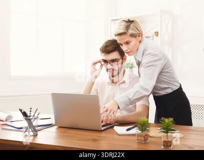 Working on a Project in an Office Setting With Two Colleagues Collaborating on a Laptop Stock Photo