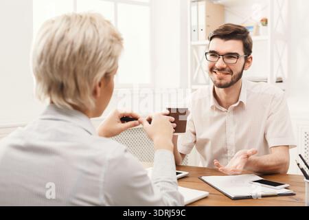Discussion Over Coffee Between Two People at a Workspace in the Afternoon Stock Photo