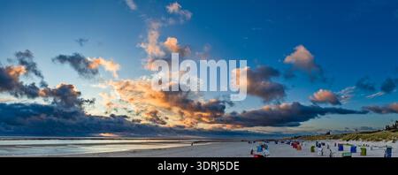 Wispy clouds illuminated by the setting sun over the North Sea on the beach at Utersum on the North Frisian island of Föhr Stock Photo