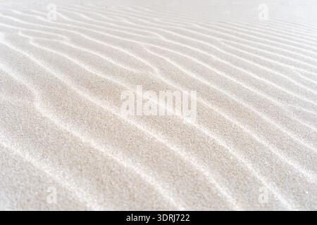 Close-up view of delicate ripple patterns naturally formed by wind across fine sand dunes, creating a minimalist abstract textur Stock Photo