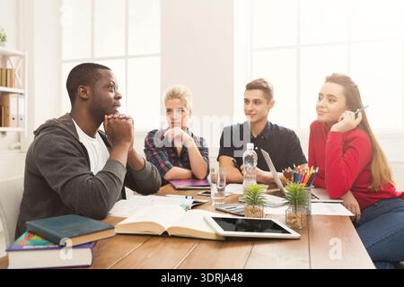 Students Collaborate on a Project During Study Session in Bright Room Stock Photo