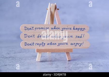 Motivation quotes about everyday actions and emotions in life.Phrases written on the popsicle sticks on the wooden easel on the gray background. Stock Photo