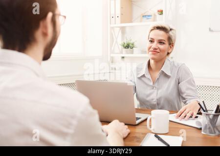 Discussion Between Two Colleagues in a Modern Office Setting During Daytime Hours Stock Photo
