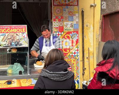 Mercato Ballarò, Palermo, Sicily. Street food vendor preparing Tigghiole bread at a stall decorated with traditional Sicilian ceramic tiles. Sicilian Stock Photo