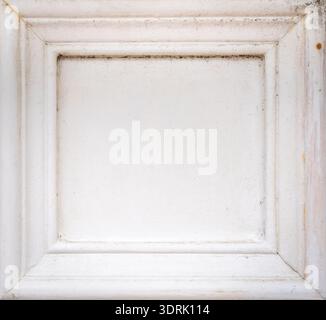 Rusty nails on a white wooden frame with peeling paint Stock Photo