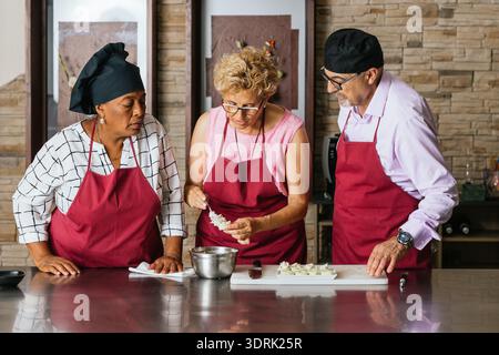 Chefs preparing ingredients during cooking course in restaurant kitchen Stock Photo