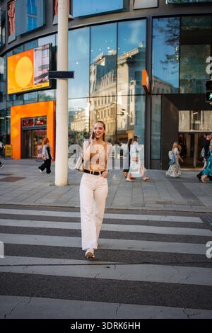 Young woman confidently walking, talking on phone in Vienna Stock Photo