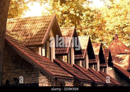Row of gabled roofs with terracotta tiles and stone walls bathed in warm autumn sunlight Stock Photo