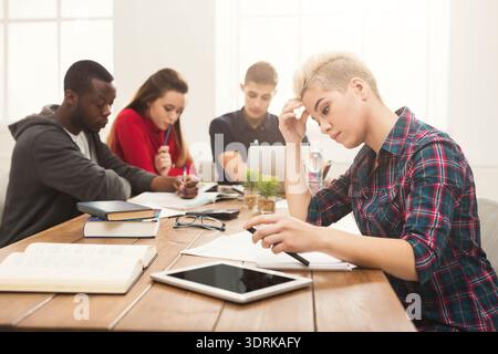 Students Working Together on Assignments in a Study Group Setting During Daytime in a Bright Room Stock Photo