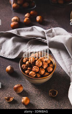 Nourishing hazelnuts without shells in a bowl for diet on the table vertical view Stock Photo