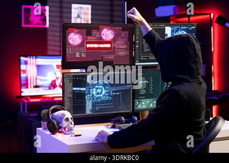 Jolly cybercriminal in apartment pumping fists in celebration after managing to steal sensitive data. Radiant rogue programmer delighted after obtaining sensitive information from users using virus Stock Photo