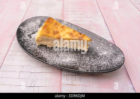 a traditional cheesecake, tall and firm, with a uniform golden color and slightly toasted edges, resting on its crumbly biscuit base. Stock Photo