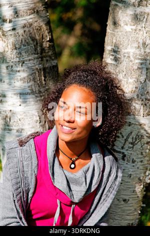 Young woman leaning against a tree, Hanover, Lower Saxony, Germany Stock Photo