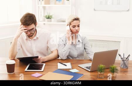 Team Members Working at a Desk With Technology in a Modern Office Setting Stock Photo