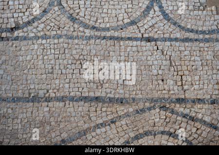 Close-up detail of Roman mosaic tesserae with curved blue lines at the Roman thermae of Herrera, Seville province, Andalusia, Spain. Stock Photo