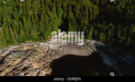 Stunning aerial view of Norways serene forest and rocky shoreline at midday Stock Photo