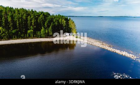 Aerial view of a serene lake with lush green islands and distant hills ...