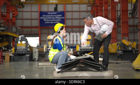 Senior engineers and young female workers are talking and inspecting steel plates Stock Photo