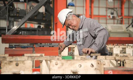 Industrial worker in protective gear experiencing chest pain while working Stock Photo