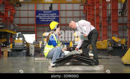 Senior engineers and young female workers are talking and inspecting steel plates Stock Photo