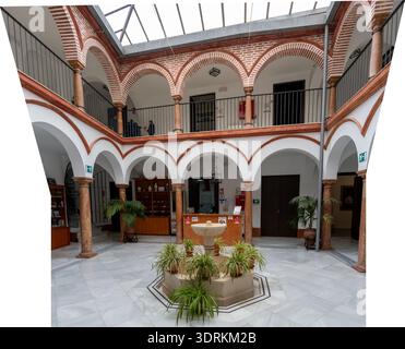 Panoramic view of an Andalusian courtyard with arches, columns, and a central fountain at the Museo de Osuna in Osuna, Andalusia, Spain. Stock Photo
