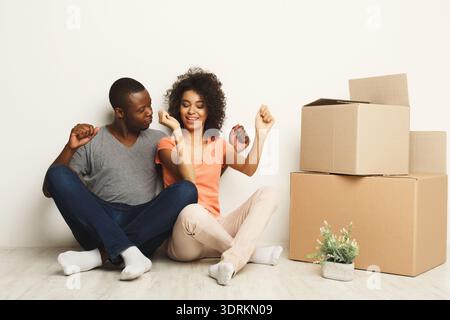 Couple Enjoys Time Together While Unpacking Boxes in New Home in the Living Room Stock Photo