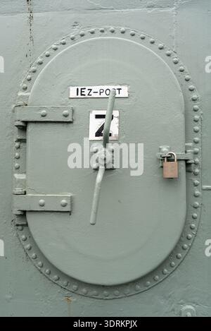 Heavy-duty metal hatch on a military vessel with secure locking system Stock Photo