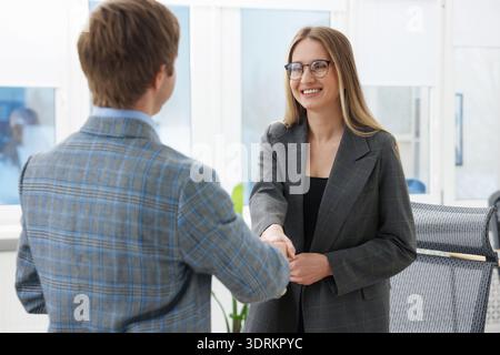 Smiling recruiter and candidate shaking hands in office Stock Photo
