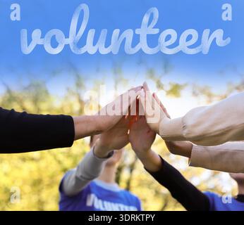 Volunteer. Group of people joining hands together outdoors, closeup Stock Photo