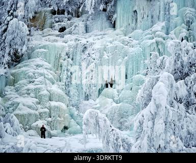 An ice climber prepares to scale the frozen Mammoth waterfall, or Mammutti, Korouoma Canyon, Finland Stock Photo