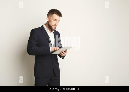 Businessman Using Tablet in a Modern Office Setting During a Workday Stock Photo