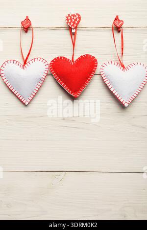 Collection of Handmade Felt Hearts Hanging on a String With Wooden Background Stock Photo