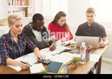 Group of Students Working Together on Projects and Studying in a Bright Room With Tables Stock Photo
