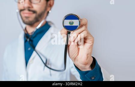 Doctor holding stethoscope with El Salvador flag. El Salvador health and care concept. El Salvador flag on stethoscope Stock Photo