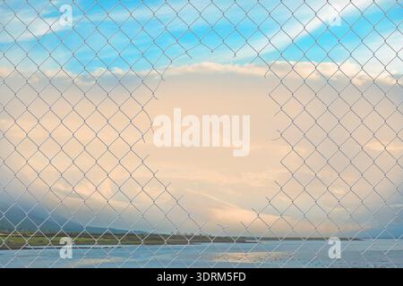 A hole in the wire mesh fence Stock Photo