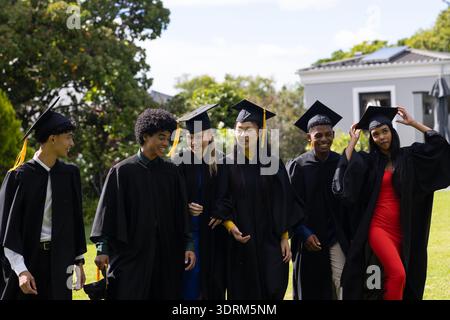 In school, graduating students wearing caps and gowns celebrating joyfully outdoors. Graduation, ceremony, achievement, celebrat Stock Photo