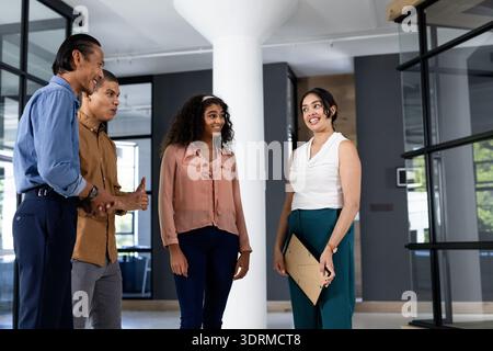 Diverse business team discussing project in modern office, smiling and engaged. Teamwork, collaboration, corporate, diversity, b Stock Photo