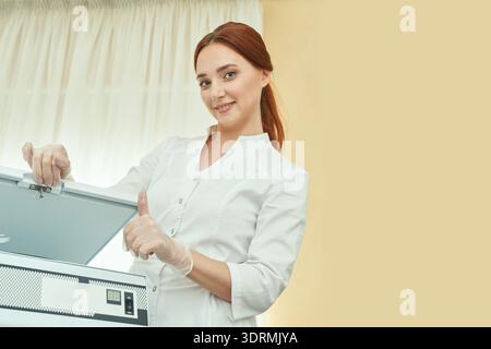 Young caucasian female lab technician in white coat opening sterile equipment Stock Photo