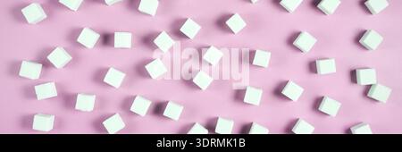 Geometric arrangement of white sugar cubes on pastel pink background Stock Photo