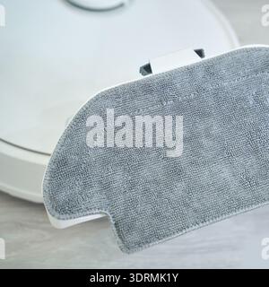 Hand holding robotic vacuum mop attachment for efficient home cleaning on light Stock Photo