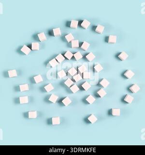 Scattered sugar cubes on light blue background in random pattern Stock Photo