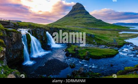 Breathtaking view of Kirkjufell mountain and its cascading waterfalls during a vibrant sunset in Iceland. The serene atmosphere Stock Photo
