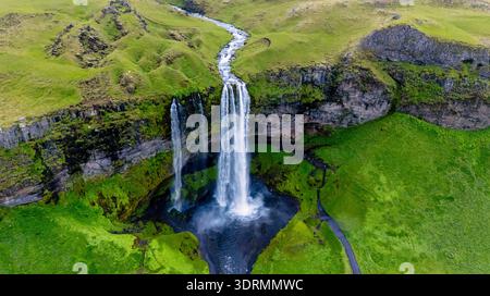 Majestic Seljalandsfoss waterfall cascading into lush green valley in Iceland Stock Photo
