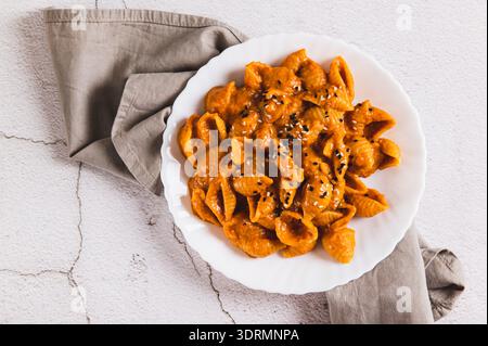 Close up of spicy miso pasta shells on a plate on the table top view Stock Photo