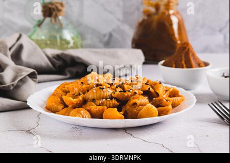 Spicy miso pasta shells on a plate on the table Stock Photo