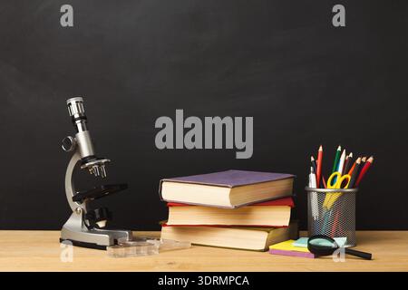 Collection of Study Tools With Microscope, Books, and Stationery on Wooden Table Stock Photo
