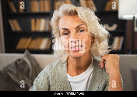 Portrait of confident stylish European middle aged senior woman. Older mature 60s lady smiling at home. Happy attractive senior Stock Photo
